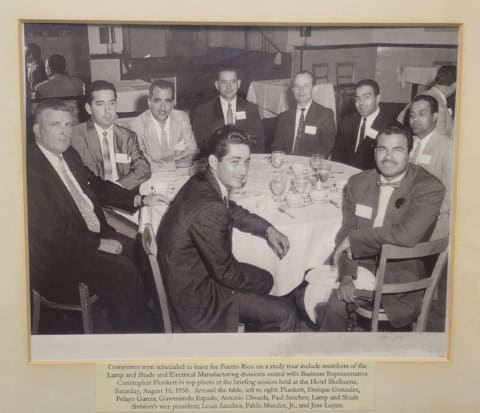 Group of men in formal attire at a board meeting, seated around a table.