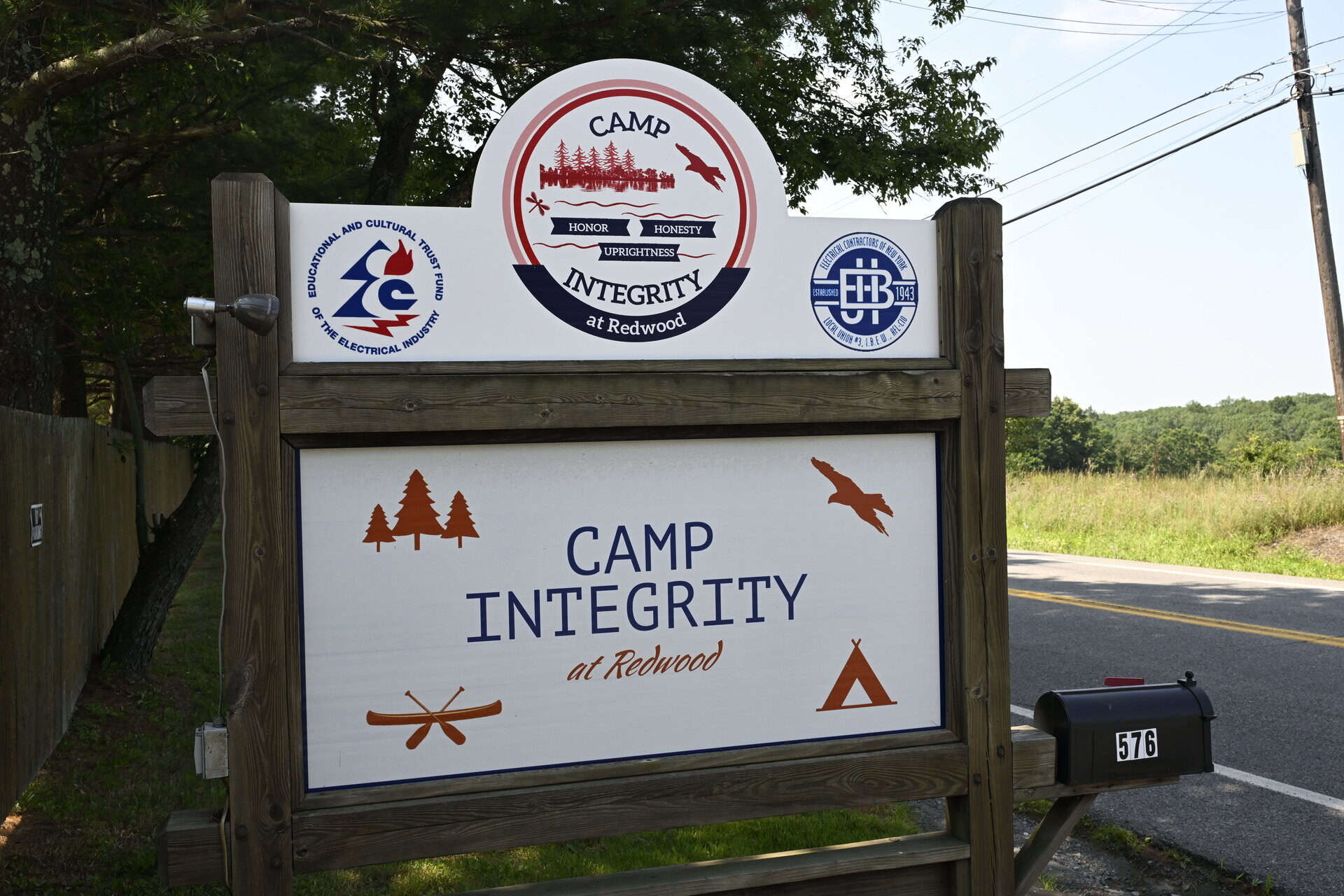 Camp Integrity sign at Redwood with logos and nature symbols.