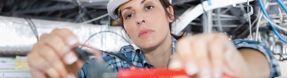 Electrical industry workers collaborating on wiring tasks.