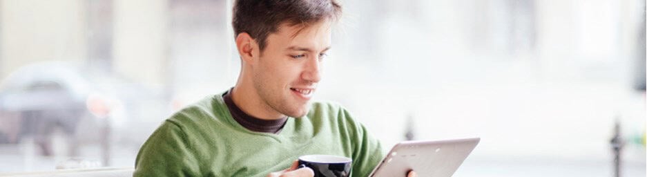 Young electrician reviewing documents at a tablet in a bright office.