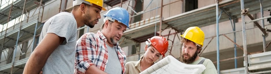 Electrical industry workers reviewing plans on site.