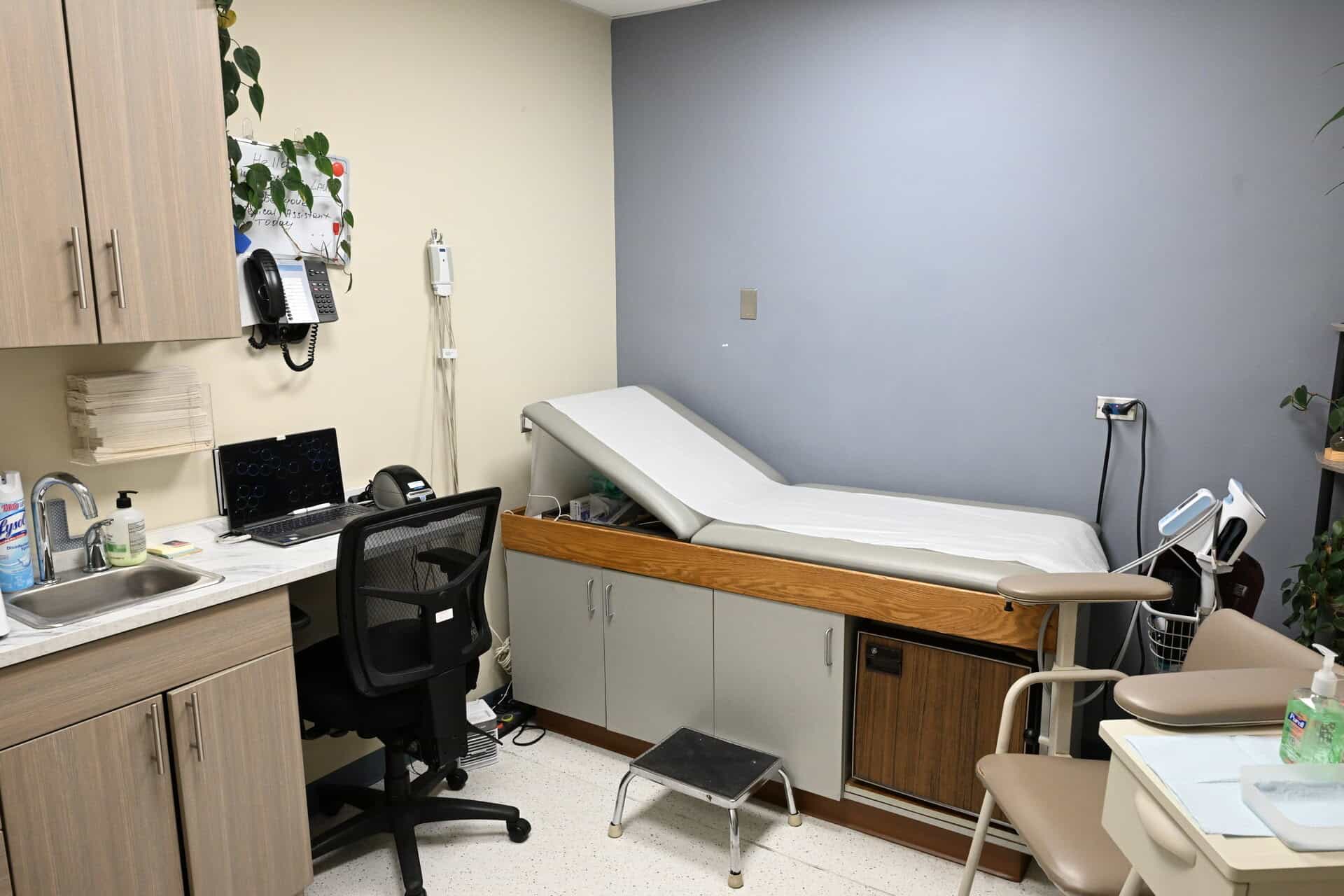 Medical examination room with hospital bed and medical equipment.