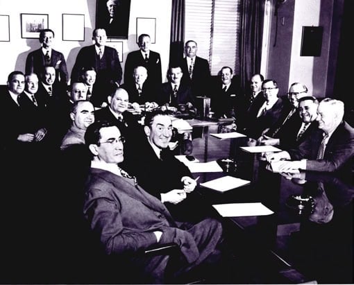 Board members gathered in a historic meeting room.